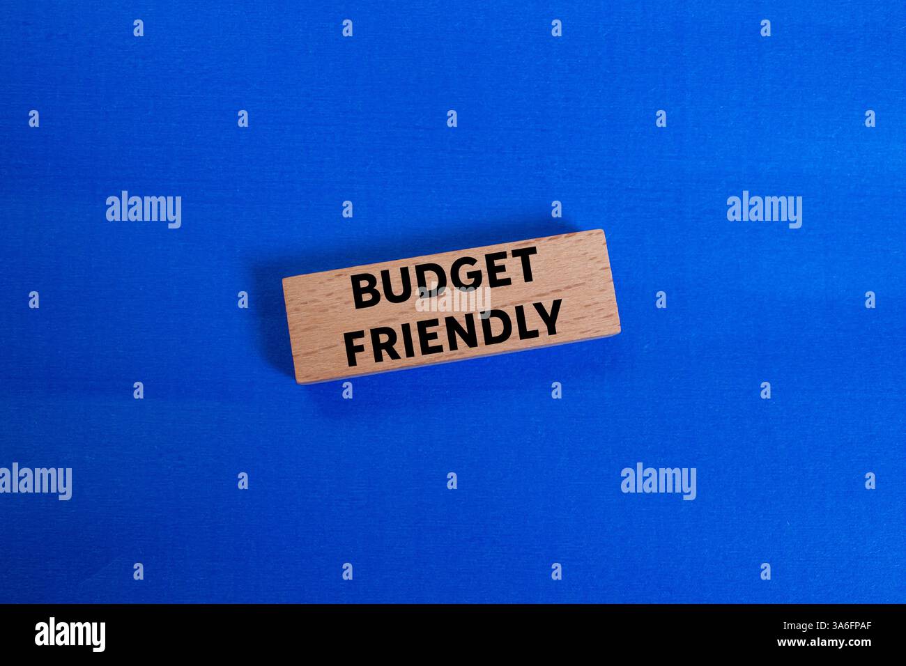 Preisfreundliche Botschaft auf Holzblock auf blauem Hintergrund. Konzeptionelles, budgetfreundliches Symbol. Kopierbereich. Stockfoto