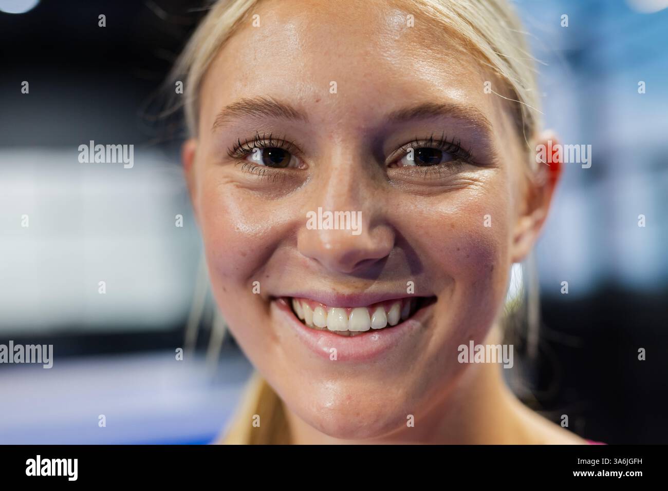 Lächelnde Frau genießt Padel-Tennis-Match, zeigt Aufregung und Energie Stockfoto