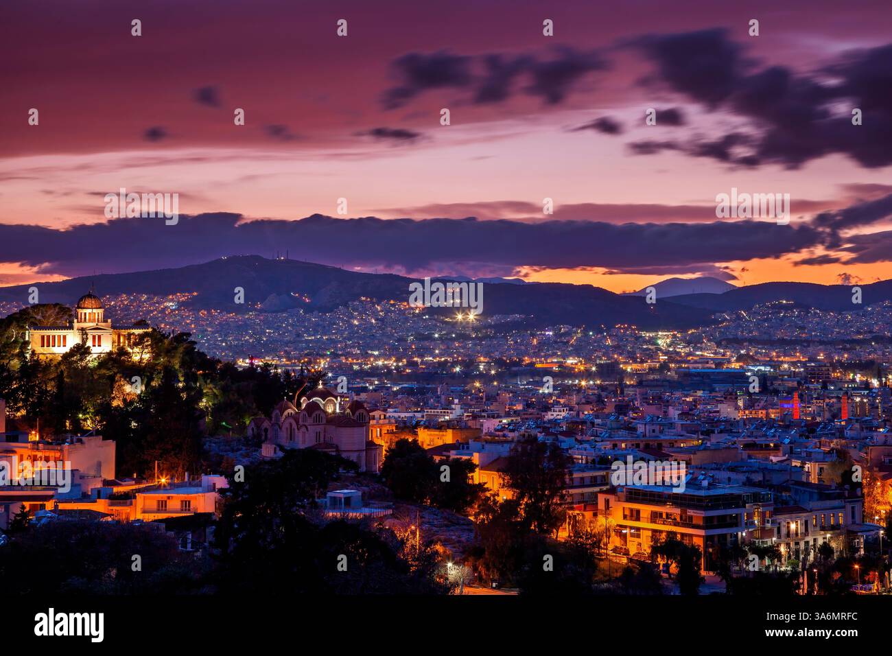 Atemberaubende Aussicht auf Athen bei Sonnenuntergang, mit beleuchteten Gebäuden und einem dramatischen Abendhimmel. Eine atemberaubende Mischung aus Geschichte und modernen Stadtlichtern. Stockfoto