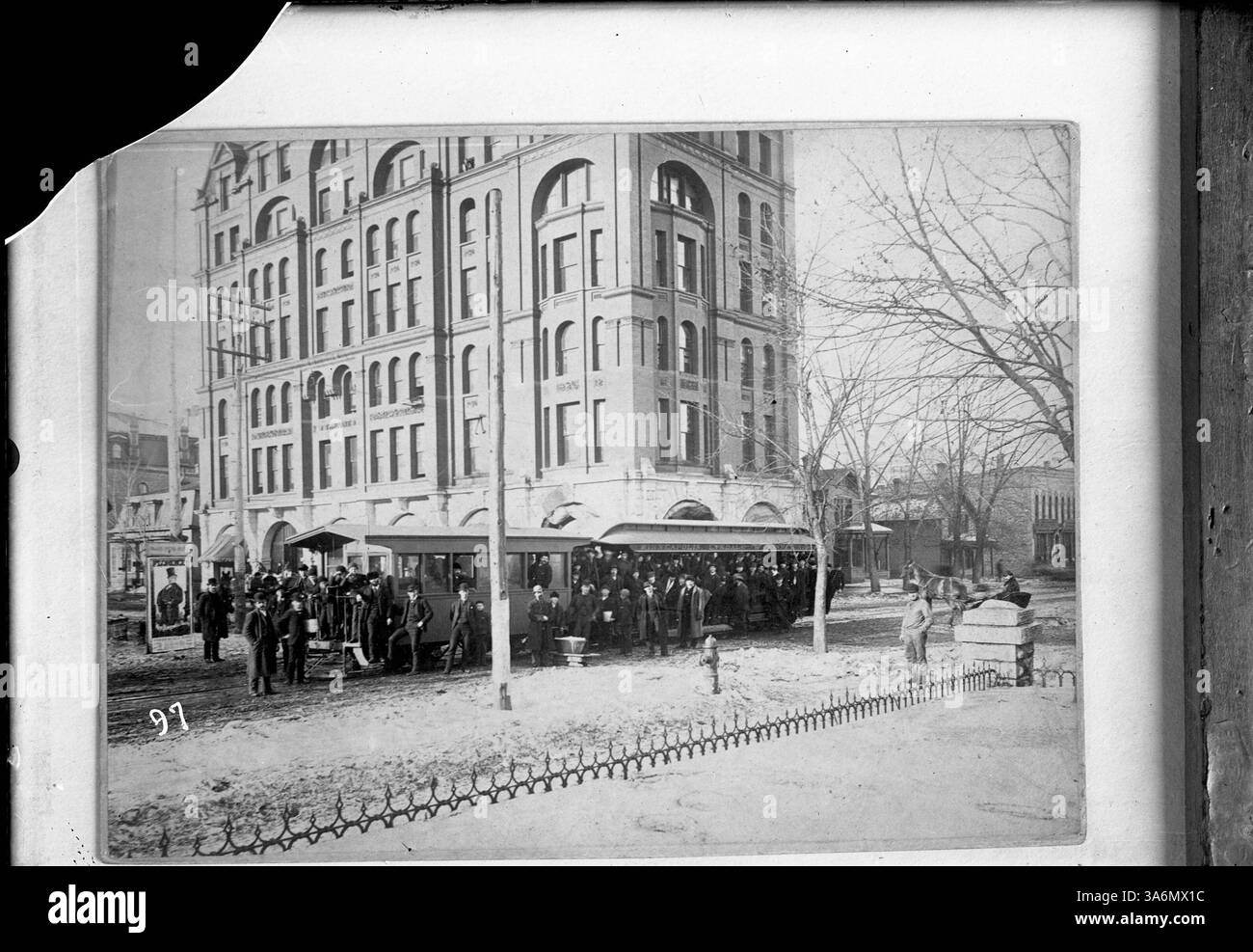 Ein historisches Foto zeigt Straßenbahnen vor dem Tribune Building mit einer großen Gruppe von Männern, die auf den Trolley-Wagen posierten. Auf dem Bild ist ein Poster für die Show „Florenz“ zu sehen. Stockfoto