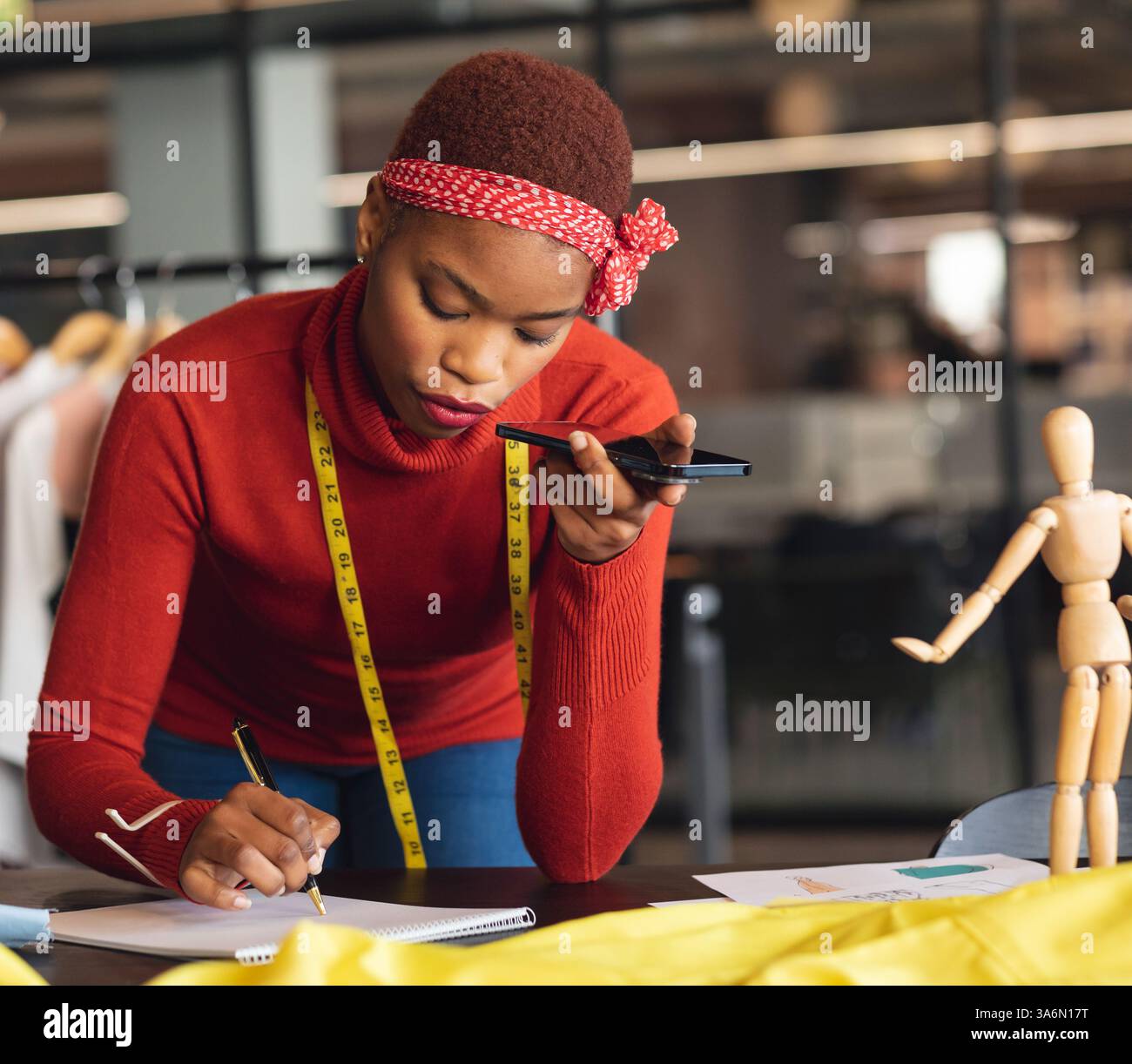 Tonnotiz beim Zeichnen, Afroamerikanerin im Modestudio Stockfoto