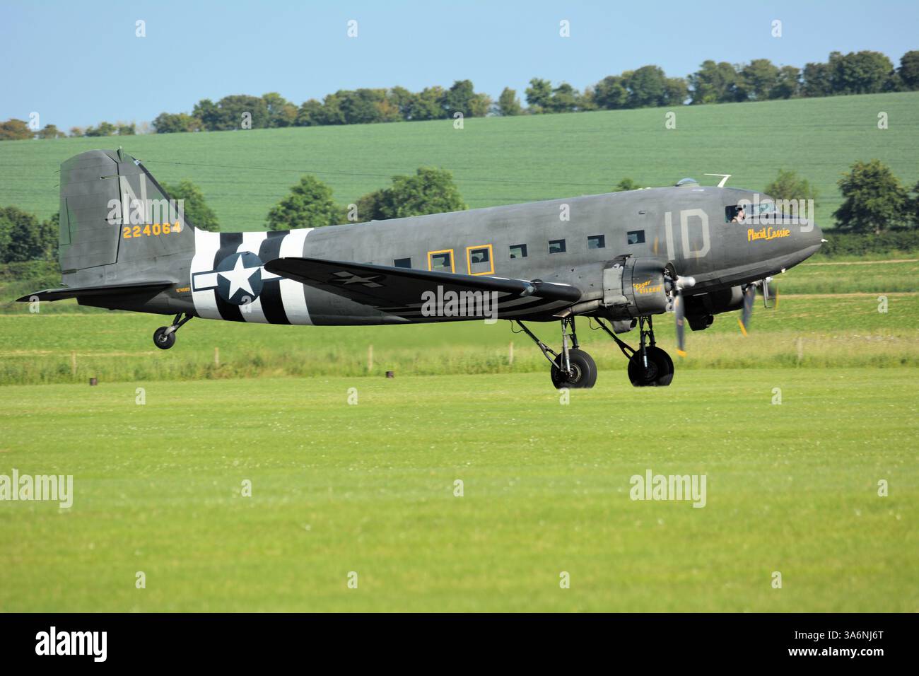 Placid Lassie, ein C-47 Skytrain, der von der IWM Duxford in Cambridgeshire abhebt, um einen D-Day Fallschirmjäger der US-Streitkräfte nachzustellen Stockfoto