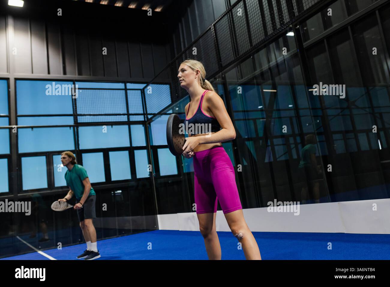 Fokussierte Spieler auf Padel Court mit Schlägern, bereit für den nächsten Zug Stockfoto