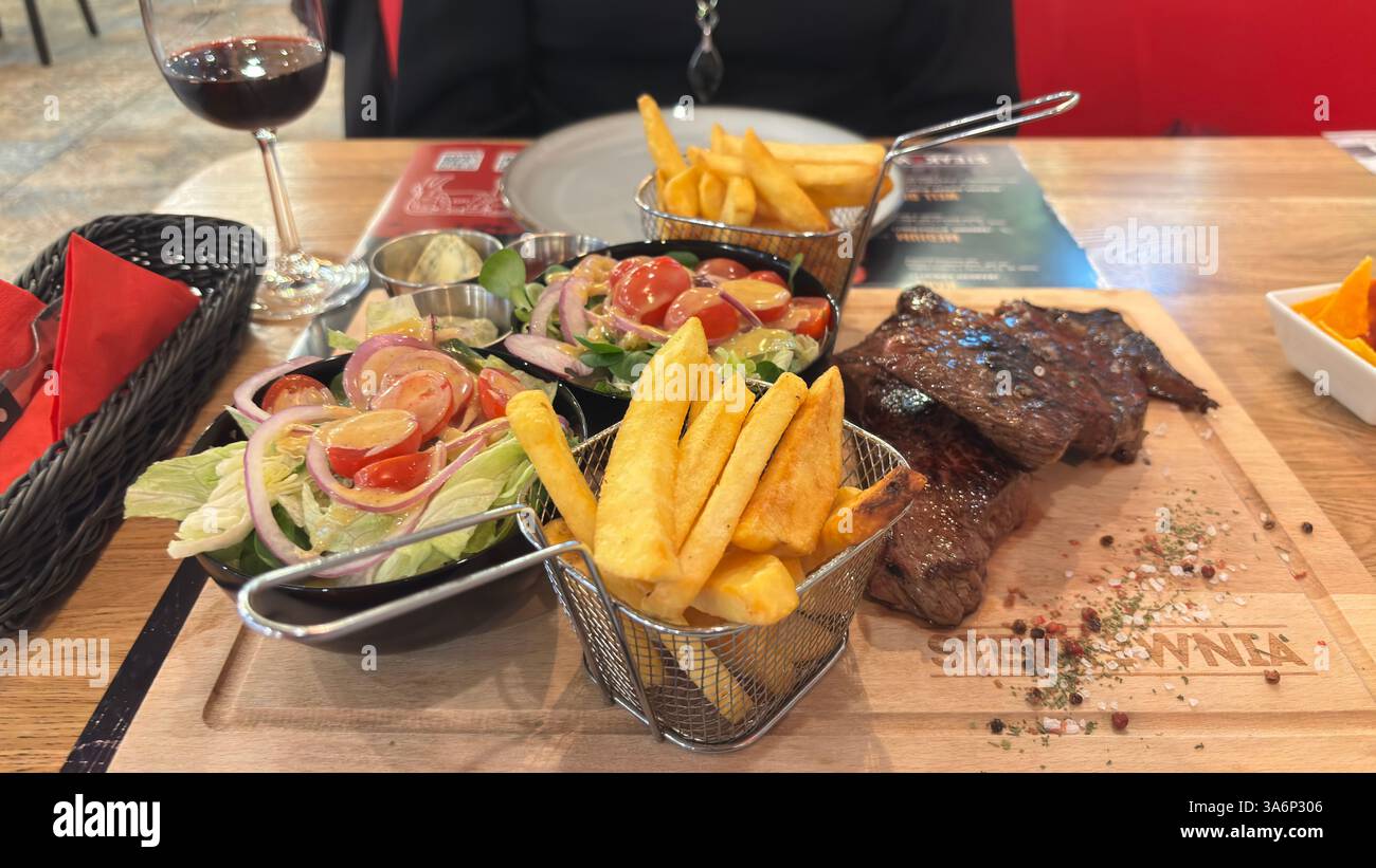 Großer Teller mit Essen. Steakabendessen mit Salat und Pommes frites - Smartphone-aufgenommenes Stockfoto