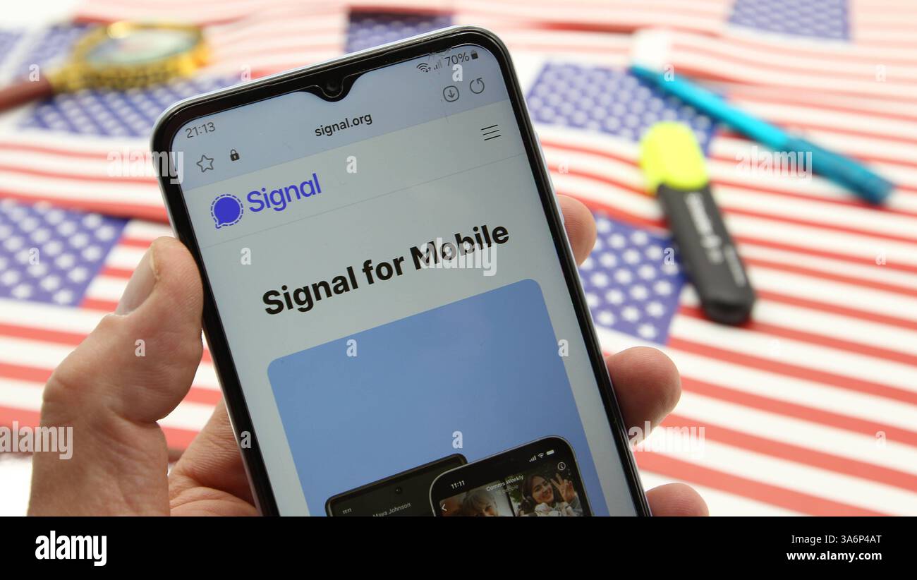 Auf einem Schreibtisch liegen Flaggen der USA, ein Textmarker und ein Kugelschreiber. Davor wurde auf einem Smartphone die Website vom Android-Messenger Signal aufgerufen. Symbolbild/Symbolfoto. Schnelsen Hamburg *** auf einem Schreibtisch befinden sich Fahnen der USA, ein Textmarker und ein Kugelschreiber davor, die Website des Android Messenger Signal wurde auf einem Smartphone aufgerufen Symbol Bild Symbol Foto Schnelsen Hamburg Stockfoto