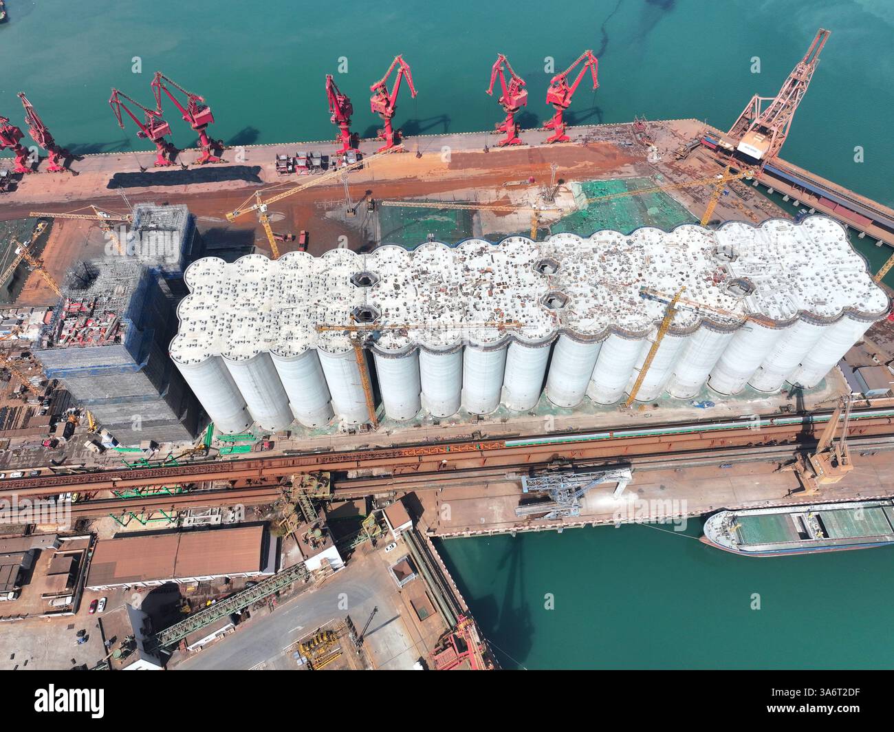Die Arbeiter führen Bauarbeiten auf der Baustelle der ersten Phase des Internationalen Getreidevertriebszentrums in Lianyungang, Ostchinas, durch Stockfoto
