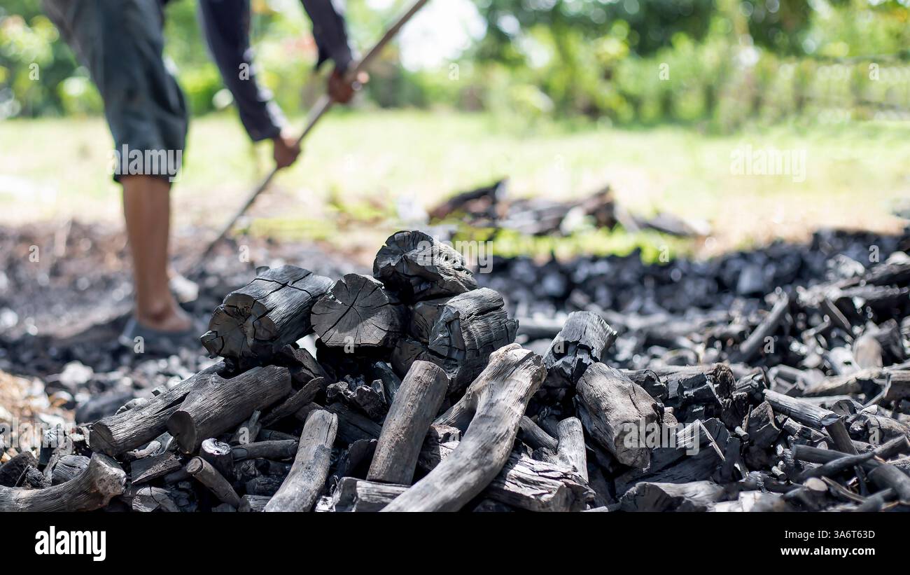 Die Bauern verbrennen Holzkohle aus Holz, das von der Farm abgeschnitten ist. Stockfoto