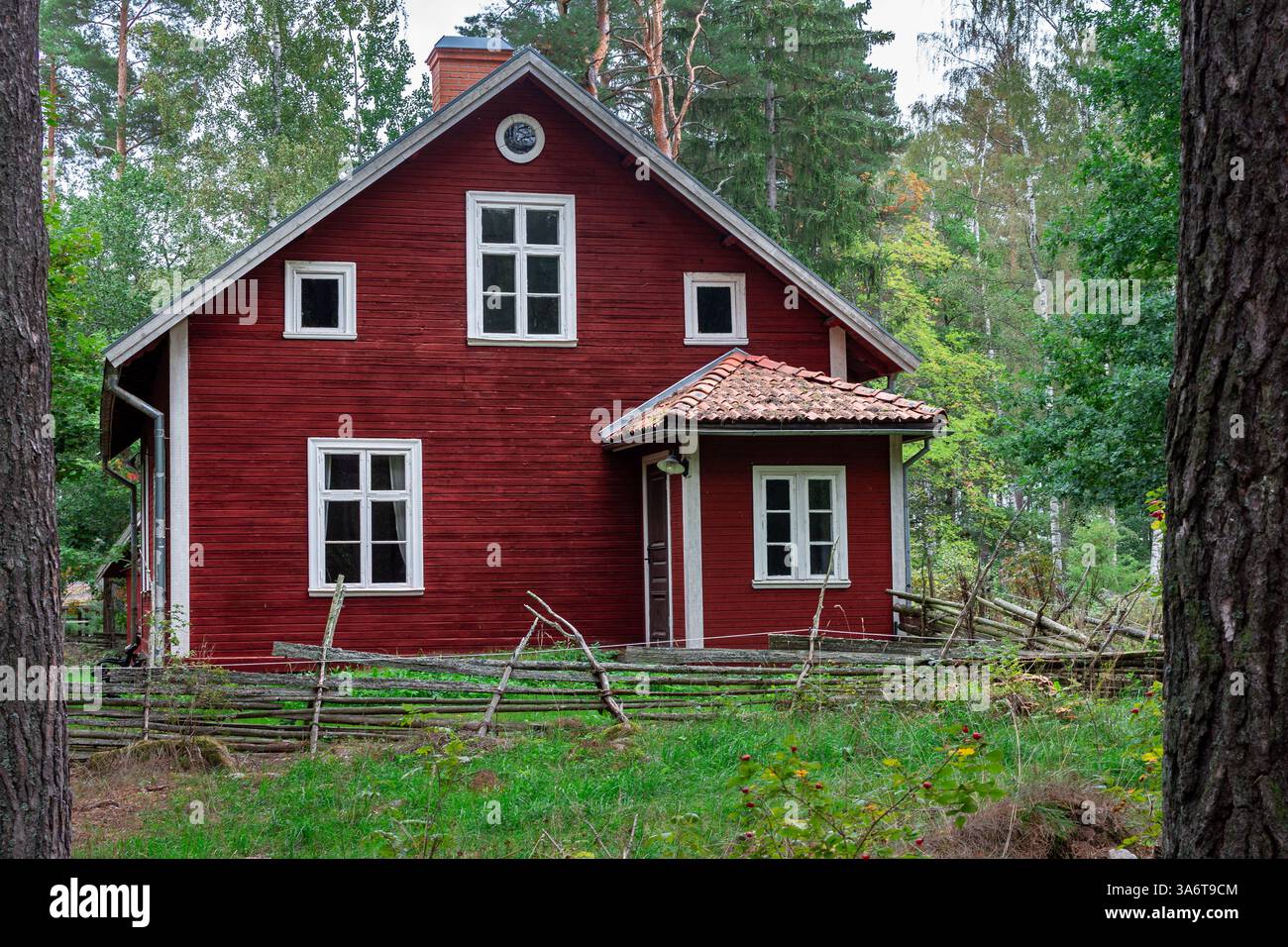Großes schwedisches rotes Holzhaus im Wald Stockfoto