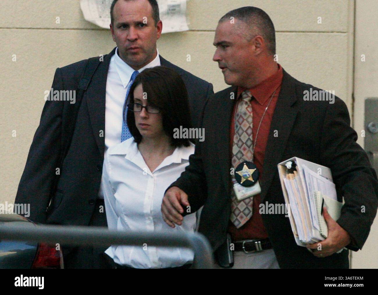 14. Oktober 2008: Casey Anthony, 22 Jahre alt, Mutter der vermissten dreijährigen Tochter Caylee Marie Anthony, wird von FBI-Agent Nick Savage, links, und Orange County Sheriff Detective Eric Edwards begleitet, nachdem sie am 14. Oktober 2008 wegen Mordes ersten Grades verhaftet wurde. (Red Huber/Orlando Sentinel/MCT) (Bild: © Red Huber/MCT/ZUMAPRESS.com) Stockfoto