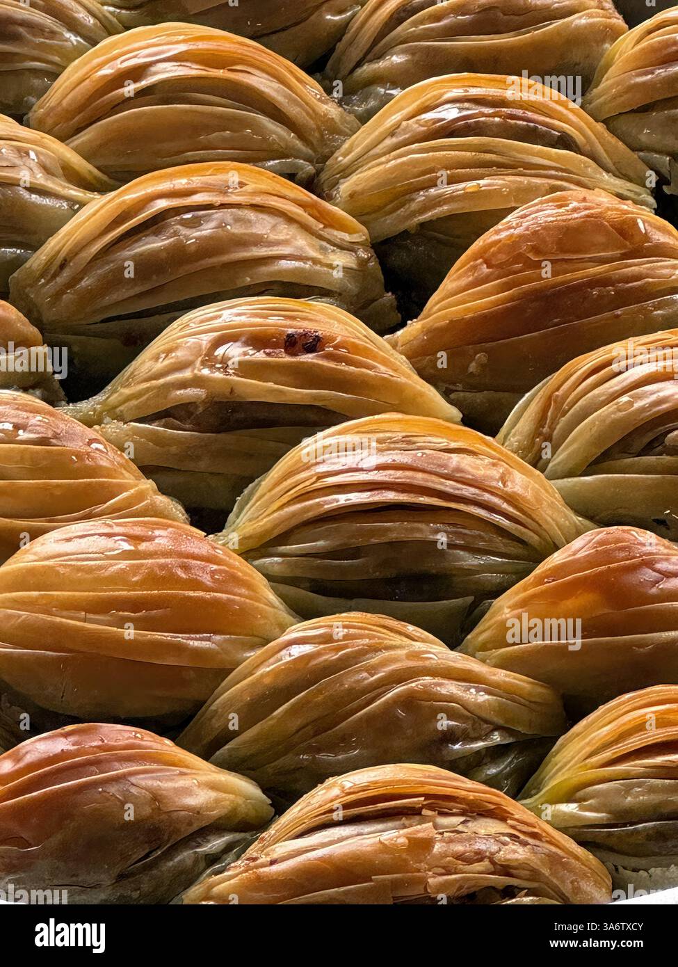 Köstliche Backwaren mit knusprigen goldenen Schichten, aus nächster Nähe fotografiert, um ihre Textur und ihren satten Ton hervorzuheben. Stockfoto