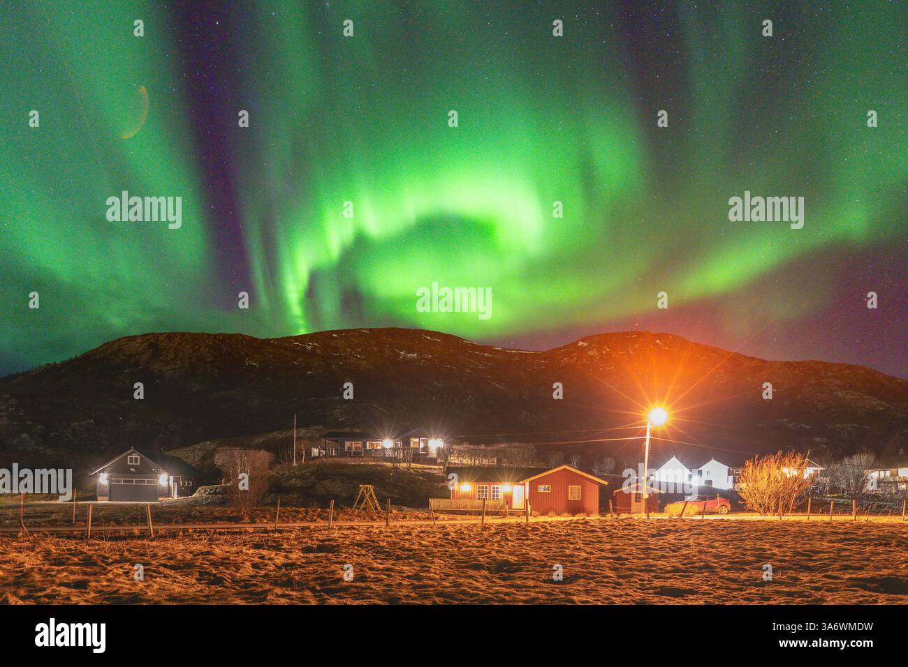 Wunderschöne Equinox Aurora Borealis über der Insel Hillesøya, tanzende Nordlichter mit klaren farbigen Lichtstrahlen am Himmel, Ferienhaus Stockfoto