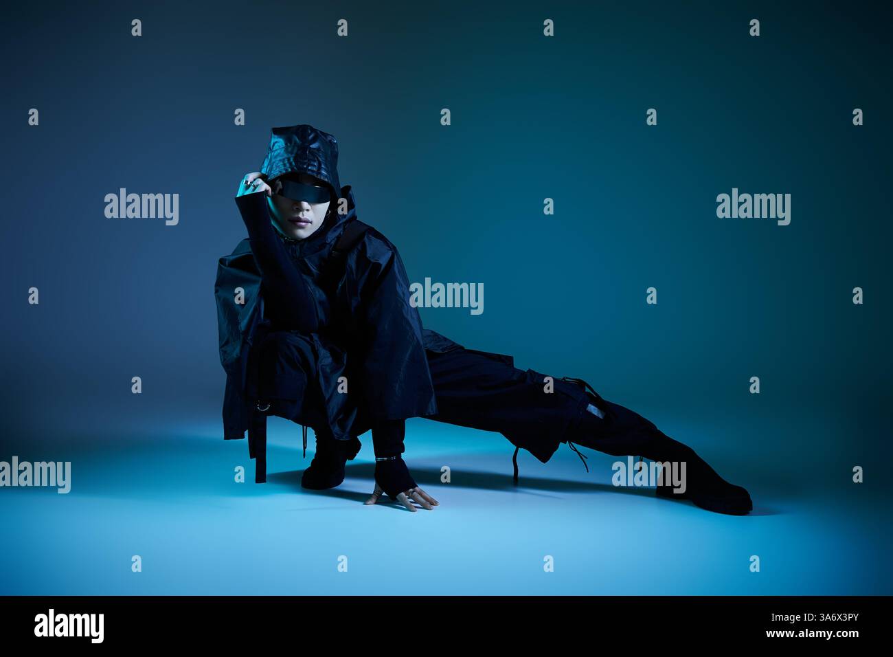 Ein stilvoller asiatischer Mann trifft eine einzigartige Pose in einer dramatischen Umgebung. Stockfoto