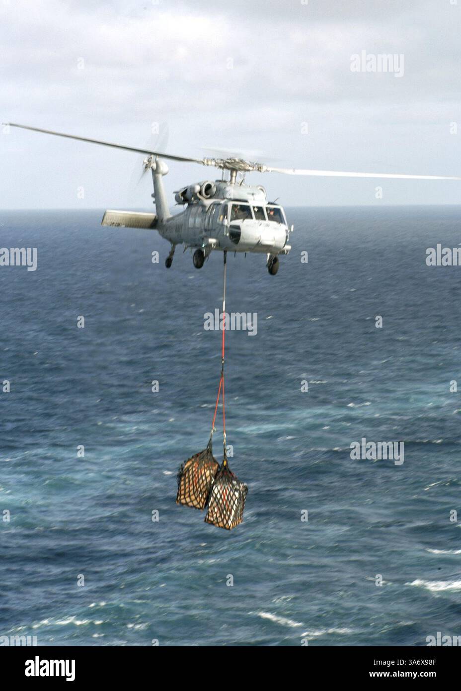 1. Juli 2004; Atlantischer Ozean; ein MH-60S KnightHawk, der den Chargers der Helicopter Combat Support Squadron Six (HC-6) zugeordnet ist, transportiert während einer vertikalen Auffüllung auf See Fracht zwischen dem Schnellkampfschiff USS Detroit (AOE 4) und dem nuklearbetriebenen Flugzeugträger USS Enterprise (CVN 65). Enterprise ist einer von sieben Flugzeugträgern, die an Summer Pulse 2004 beteiligt sind. Summer Pulse 2004 ist der gleichzeitige Einsatz von sieben Flugzeugstreikgruppen (Aircraft Strike Groups, CSGs), die die Fähigkeit der Navy demonstrieren, glaubwürdige Kampfhandlungen auf der ganzen Welt in fünf Theatern mit anderen USA, Verbündeten und Kohle durchzuführen Stockfoto
