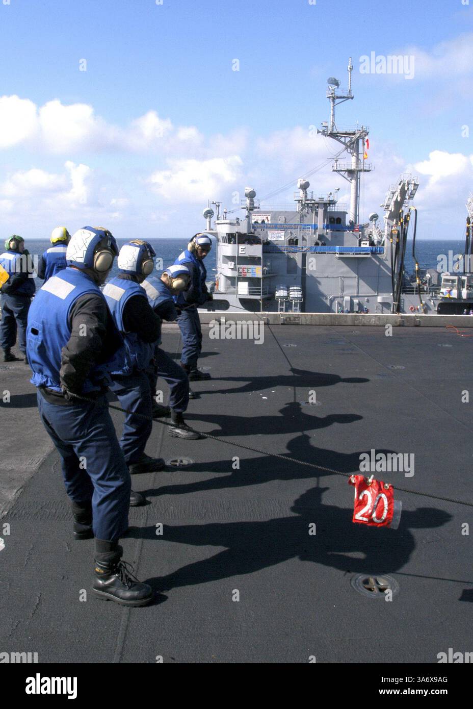 17. Juli 2004; Atlantik; Boatswain's Mates, die dem Deck Department zugeteilt sind, übernehmen eine Linie während einer laufenden Auffüllung zwischen dem Schnellkampfschiff USS Detroit (AOE 4) und dem nuklearbetriebenen Flugzeugträger USS Enterprise (CVN 65). Enterprise ist einer von sieben Flugzeugträgern, die an Summer Pulse 2004 beteiligt sind. Summer Pulse 2004 ist der gleichzeitige Einsatz von sieben Flugzeugstreikgruppen (Aircraft Strike Groups, CSGs), die die Fähigkeit der Navy demonstrieren, glaubwürdige Kampfhandlungen auf der ganzen Welt in fünf Theatern mit anderen US-amerikanischen, alliierten und koalitionellen Streitkräften durchzuführen. Summer Pulse ist die erste der Navy Stockfoto