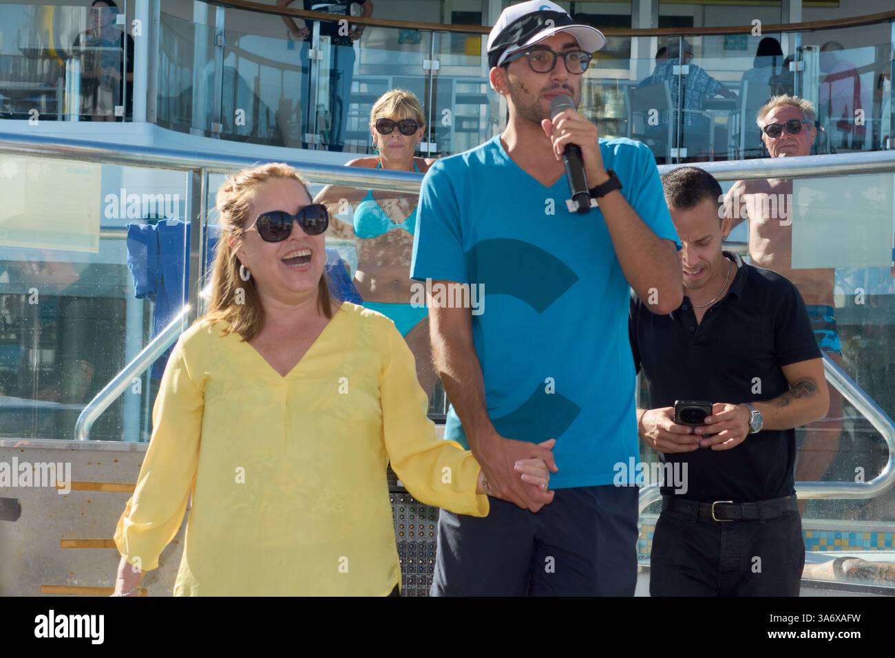 Catania. Italien - 26. März 2025: Mann spricht die Teilnehmer mit einem Mikrofon an, während die Frau sich ihm im Dialog anschließt. Lebhafte Umgebung mit lebhaftem Hintergrund Stockfoto