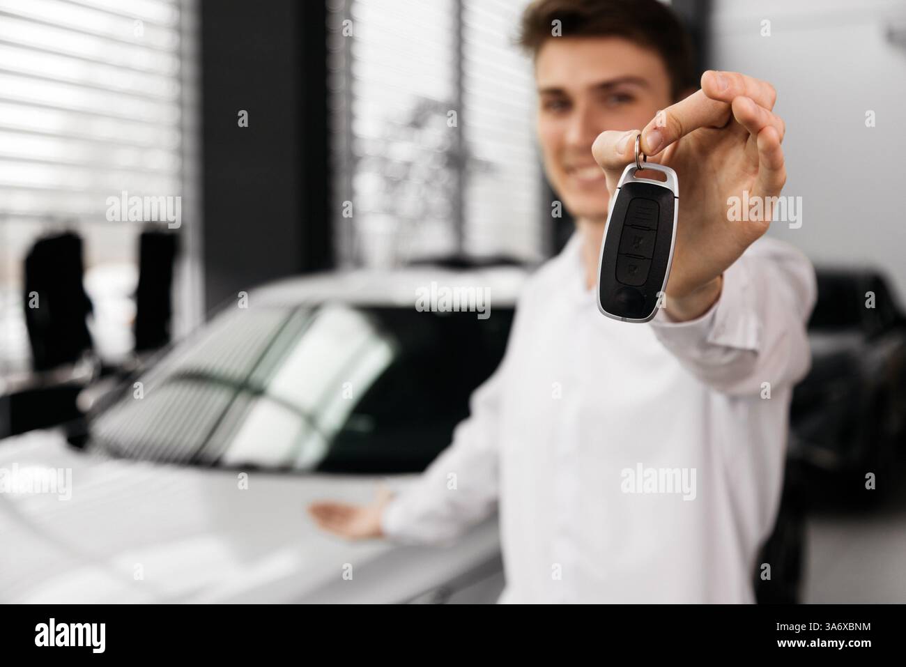 Abschluss eines Autokaufs oder Mietvertrags mit Schlüsselübergabe. Entwickeln Sie den letzten Schritt eines nahtlosen Fahrzeugkaufs, Verkaufs- oder Testfahrens Stockfoto