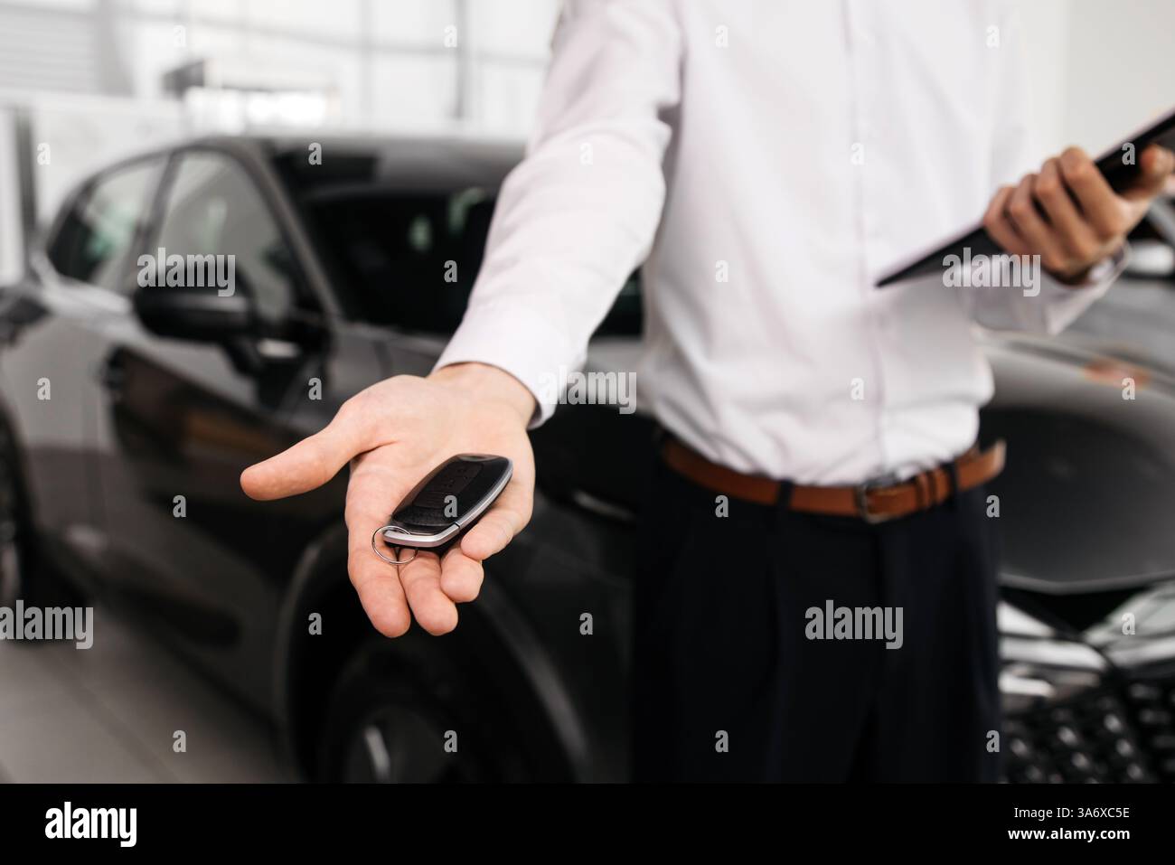 Abschluss eines Autokaufs oder Mietvertrags mit Schlüsselübergabe. Entwickeln Sie den letzten Schritt eines nahtlosen Fahrzeugkaufs, Verkaufs- oder Testfahrens Stockfoto