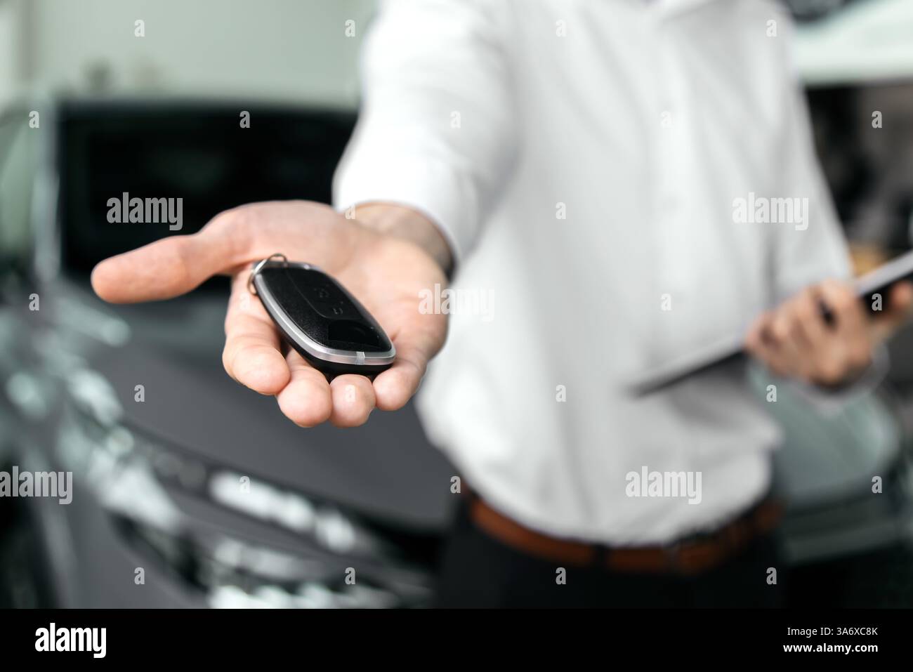 Abschluss eines Autokaufs oder Mietvertrags mit Schlüsselübergabe. Entwickeln Sie den letzten Schritt eines nahtlosen Fahrzeugkaufs, Verkaufs- oder Testfahrens Stockfoto