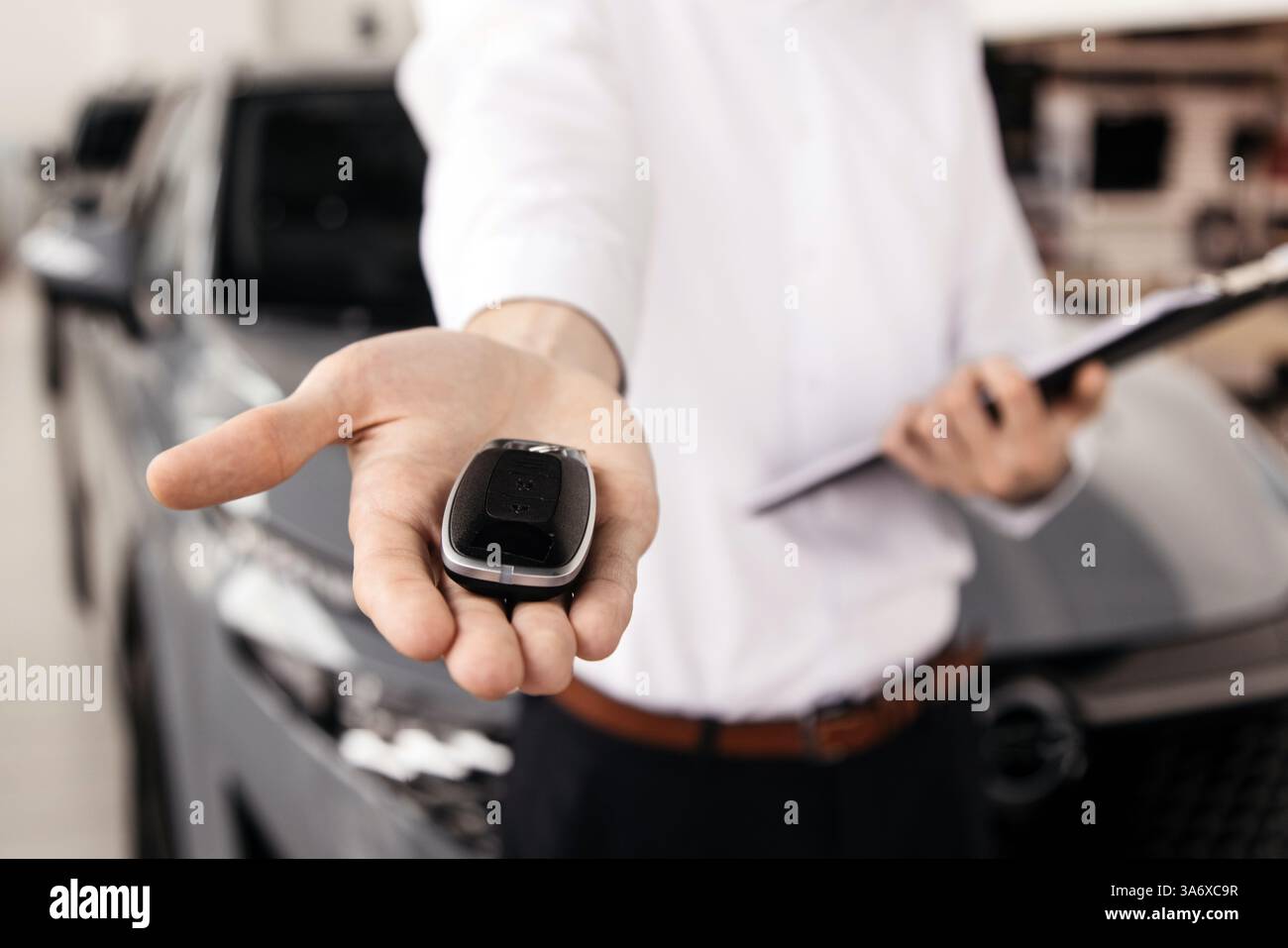 Abschluss eines Autokaufs oder Mietvertrags mit Schlüsselübergabe. Entwickeln Sie den letzten Schritt eines nahtlosen Fahrzeugkaufs, Verkaufs- oder Testfahrens Stockfoto
