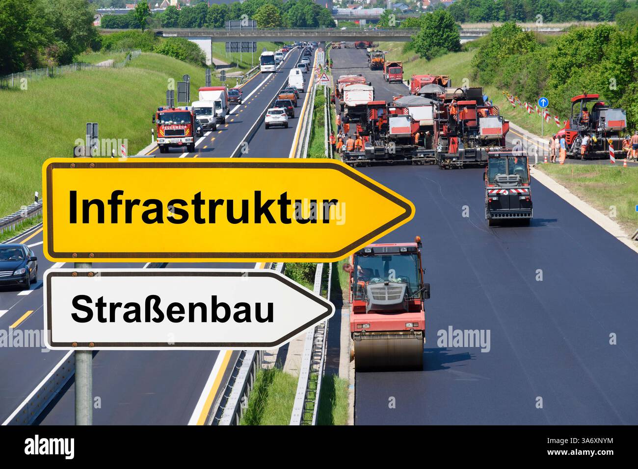 Baustelle auf einer Autobahn mit Fahrbahnerneuerung ein Wegweiser mit der Aufschrift Infrastruktur und Straßenbau steht vor einer Baustelle auf einer Stockfoto
