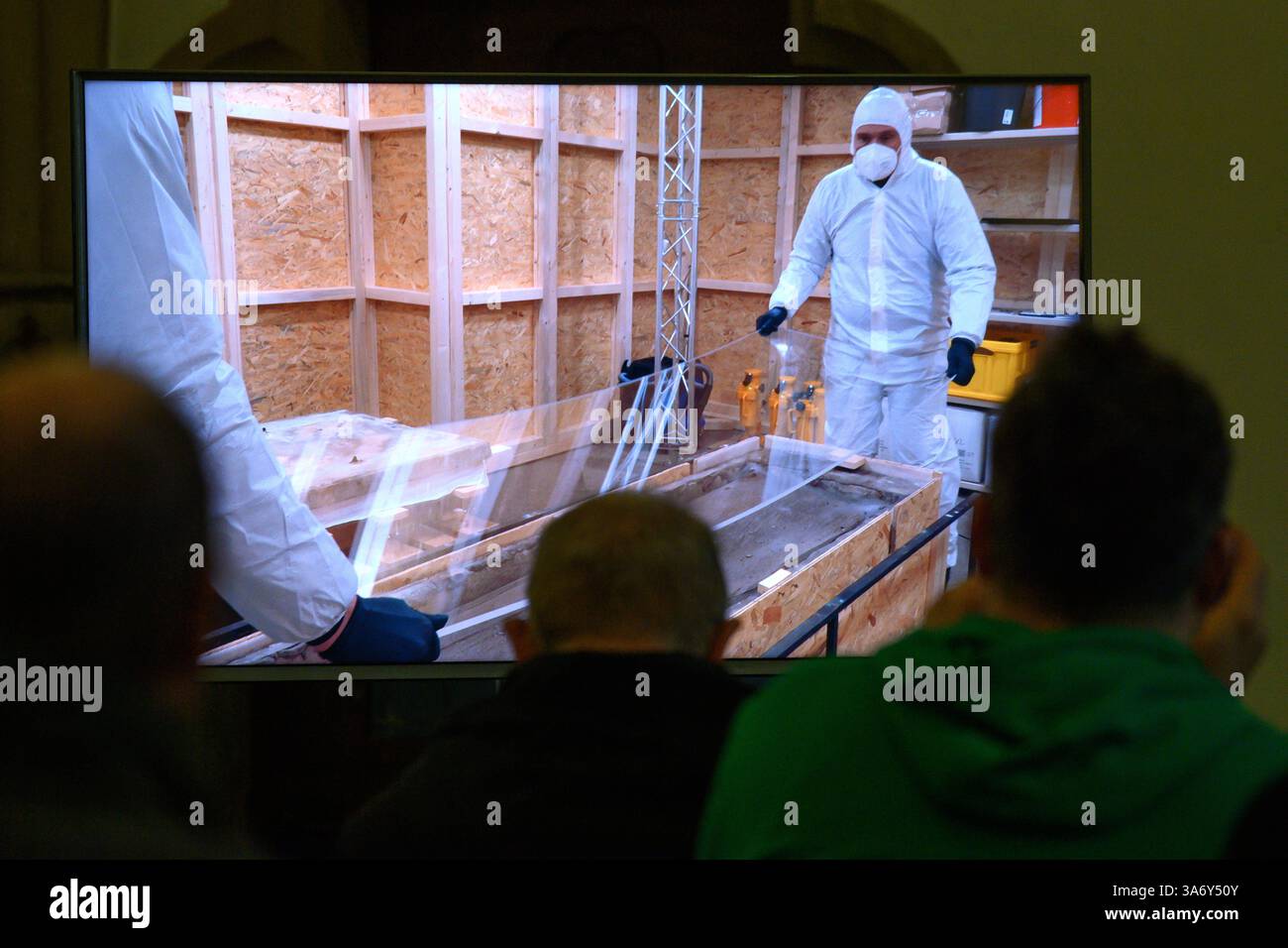 Magdeburg, Deutschland. März 2025. Ein Live-Video zeigt Archäologen, die eine Plexiglasscheibe aus dem offenen Grab Ottos des Großen im Magdeburger Dom heben. Seit Januar führen das Landesamt für Denkmalpflege und Archäologie und die Kulturstiftung Sachsen-Anhalt Untersuchungen zur Erhaltung des Denkmals durch. Frühere Ergebnisse und weitere geplante Maßnahmen werden vorgestellt. Quelle: Klaus-Dietmar Gabbert/dpa/Alamy Live News Stockfoto