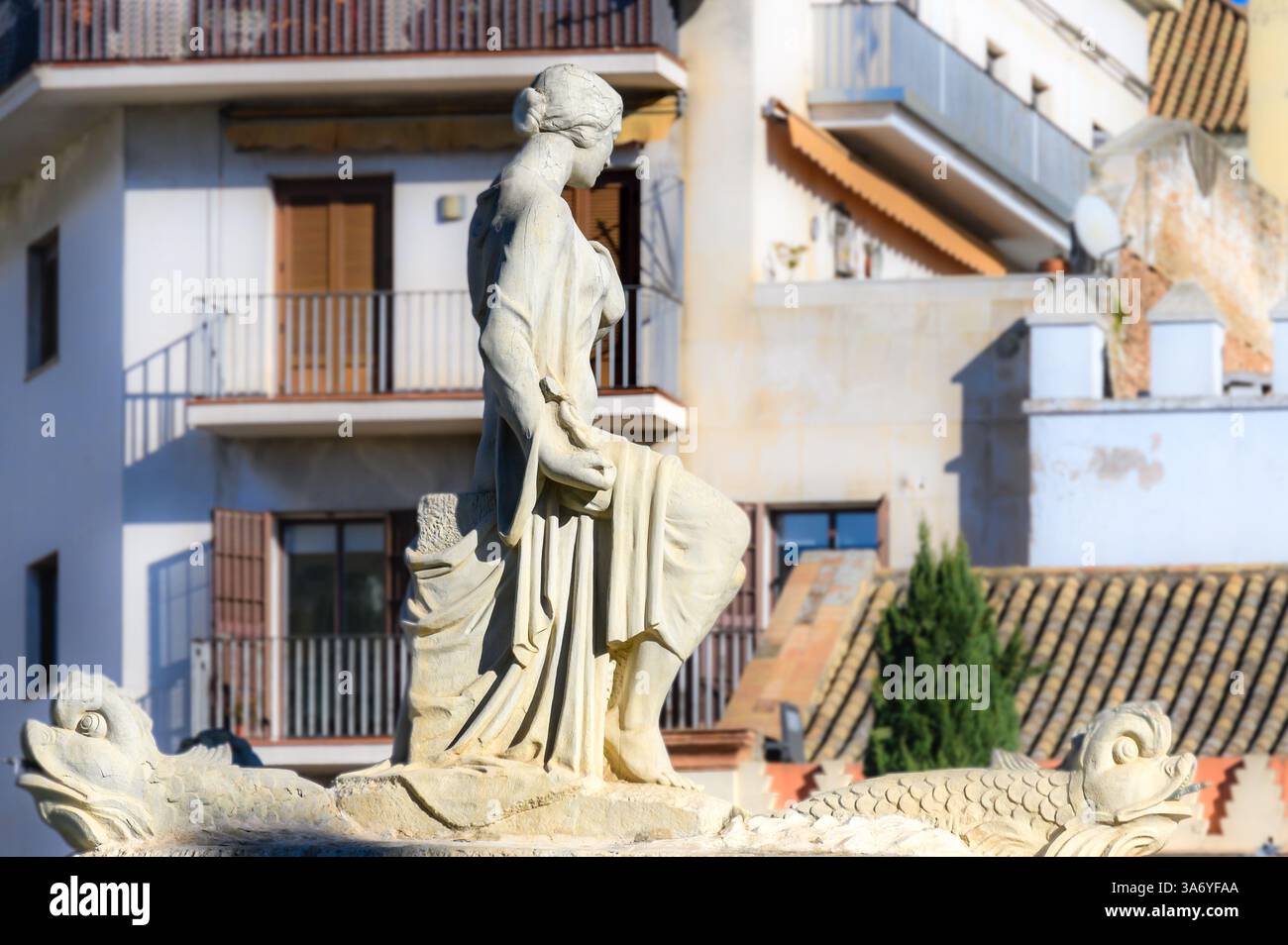 Steinskulptur mit weiblichem Bild entlang einer Stadtstraße. Stockfoto