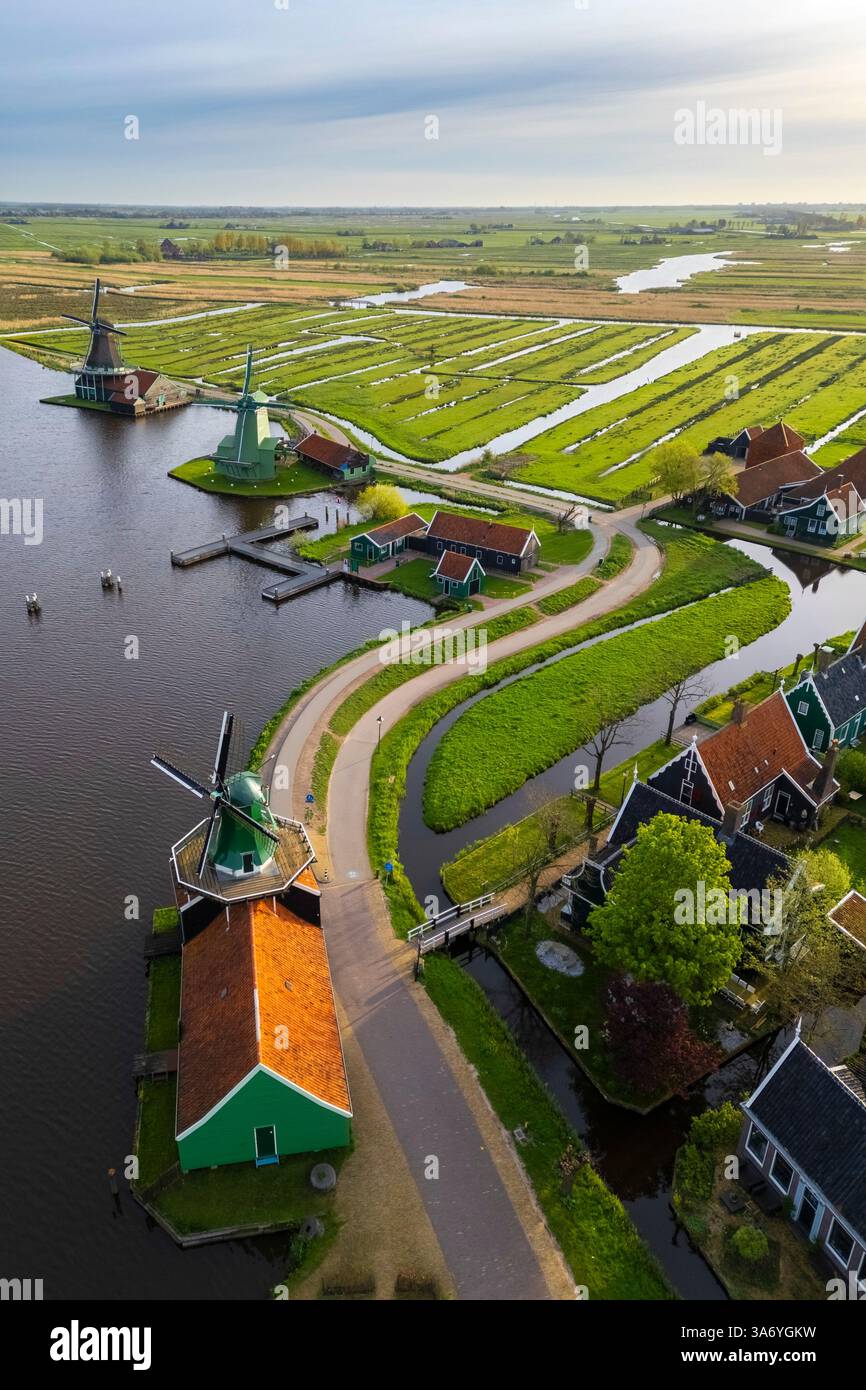 Luftaufnahme der typischen Windmühlen von Zaanse Schans auf dem Fluss Zaan im Frühling. Zaanse Schans, Nordholland, Gemeinde Zaanstad, Niederlande Stockfoto