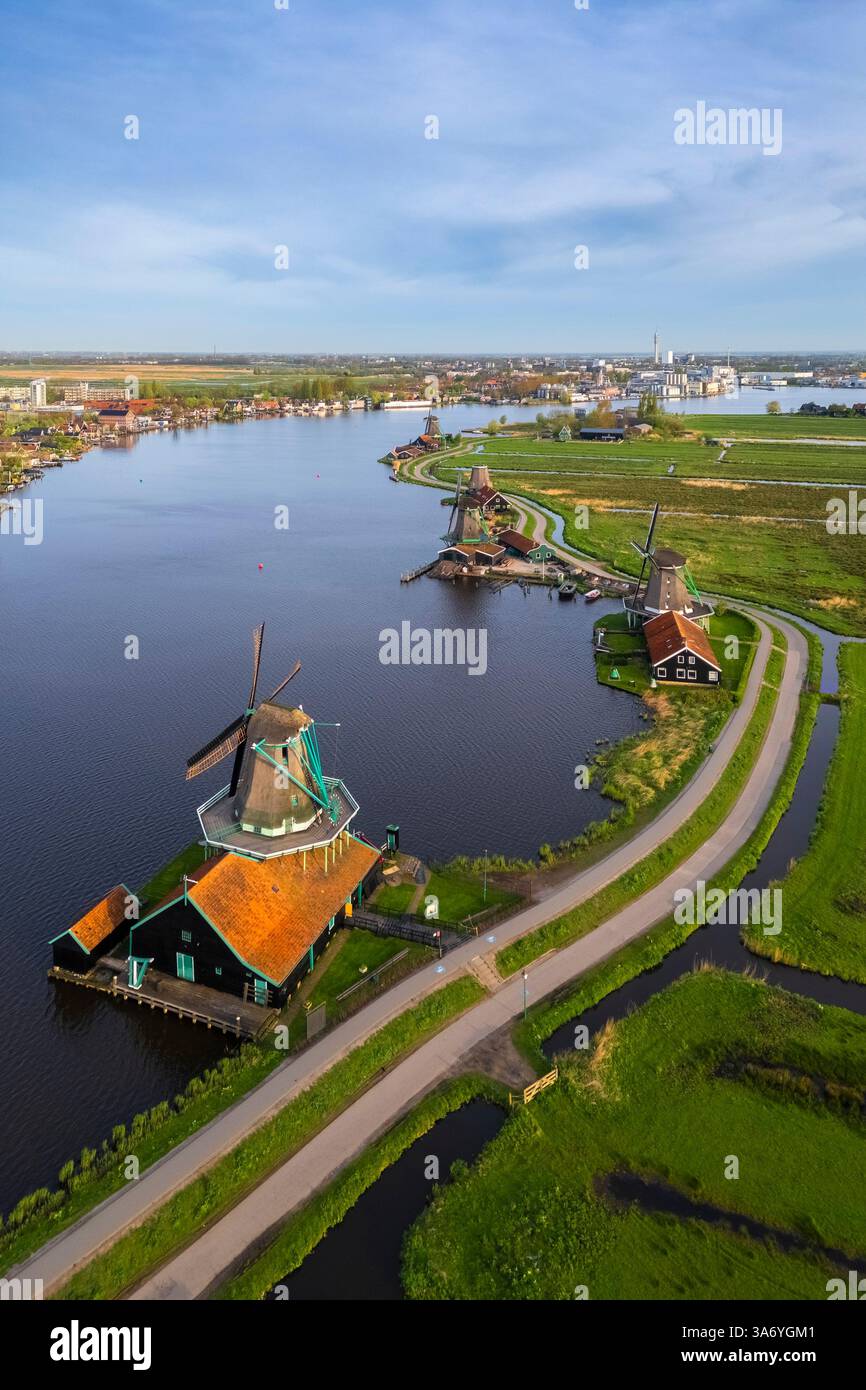 Luftaufnahme der typischen Windmühlen von Zaanse Schans auf dem Fluss Zaan im Frühling. Zaanse Schans, Nordholland, Gemeinde Zaanstad, Niederlande Stockfoto