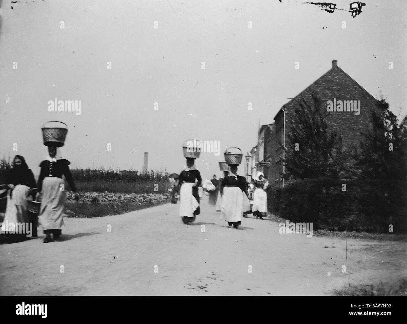 Hausangestellte in Linn, einem historischen Stadtteil der Stadt Krefeld, in Nordrhein-Westfalen. In dieser Szene werden Frauen gezeigt, die mit Körben auf dem Kopf vom Markt zurückkehren. Aus einer Sammlung von Fotografien von der Europatour einer Familie, die 1899 stattfand. Die Originalfotos waren etwa 3 ½ x 2 ½ Zoll und bieten einen interessanten Blick auf die Bräuche, Moden und Sozialgeschichte der späten viktorianischen Zeit. Stockfoto