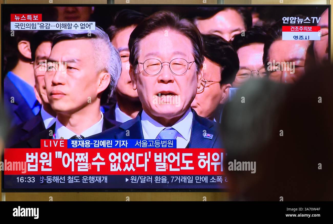 Seoul, Südkorea. März 2025. Eine 24-stündige Yonhap-Nachrichtensendung am Bahnhof Seoul zeigt Lee Jae-myung, Führer der wichtigsten oppositionellen Demokratischen Partei, mit Reportern vor dem Seoul High Court in Seoul zu sprechen, nachdem das Gericht eine Bewährungsstrafe gegen ihn aufgehoben hatte, weil er während der Wahlen 2022 als Präsidentschaftskandidat gelogen hatte und ihn von der Anklage freigesprochen hatte. Quelle: SOPA Images Limited/Alamy Live News Stockfoto