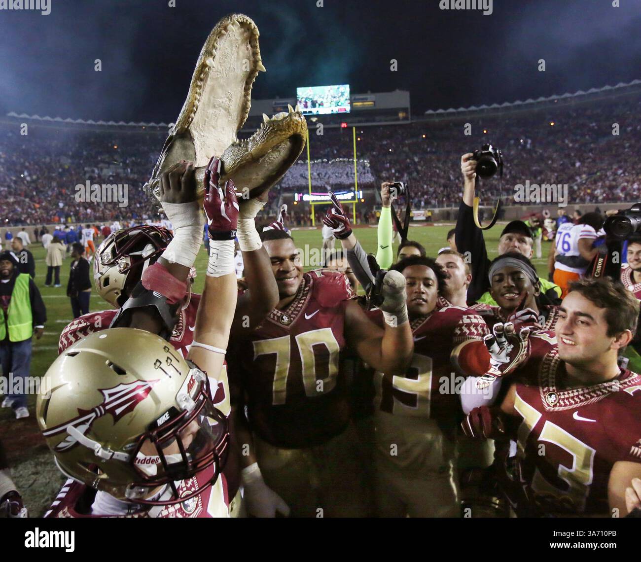 29. November 2014 - Tallahassee, FL, USA - Florida State Players feiern am Samstag, den 29. November 2014, mit einem Alligatorkopf, nachdem sie Florida mit 24:19, im Doak Campbell Stadium in Tallahassee, Florida besiegt haben. (Bild: © Stephen M. Dowell/TNS/ZUMA Wire) Stockfoto