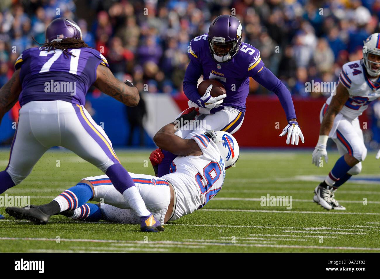 Oktober 2014 - Orchard Park, New York, USA TEDDY BRIDGEWATER (5) wird von Buffalo Bills Defensive End MARIO WILLIAMS (94) im zweiten Viertel im Ralph Wilson Stadium in Orchard Park, NY, entlassen. Minnesota führt Buffalo 13-10 in der Hälfte an. (Kreditbild: © Michael Johnson/ZUMA Wire) Stockfoto