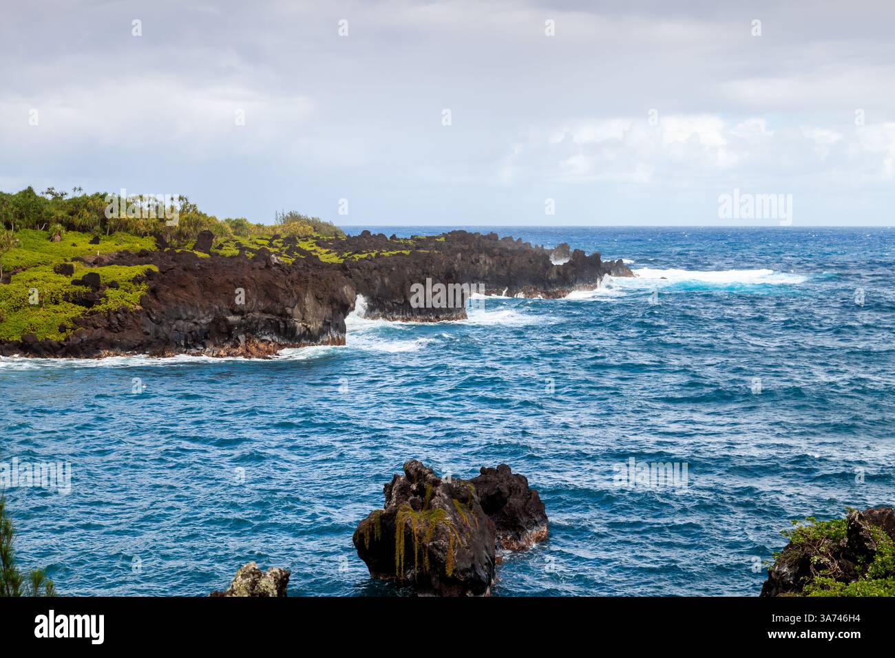 Mächtige Wellen prallen auf vulkanische Klippen in Waiianapa und zeigen die raue Schönheit der natürlichen Landschaft von Maui. Stockfoto
