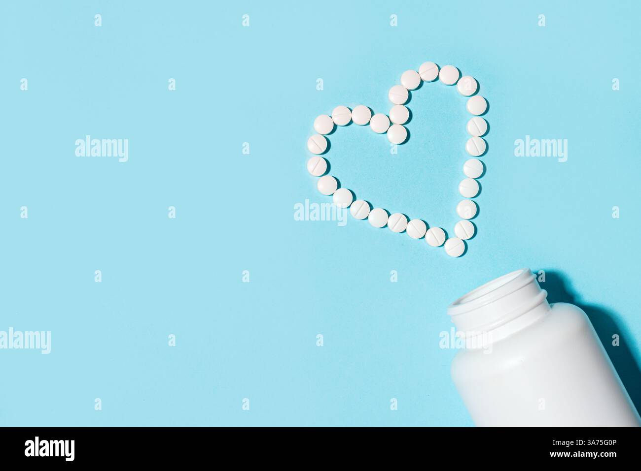 Herzform aus weißen Pillen, minimales Konzept der Herz-Kreislauf-Gesundheit auf blauem Hintergrund, Draufsicht, Kopierraum. Vorlage für Vitamine und Nahrungsergänzungsmittel. Pharmazeutischer Unternehmer Stockfoto