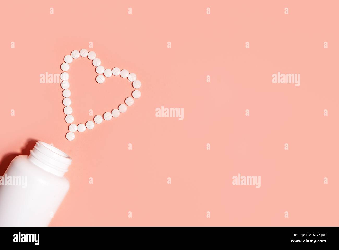 Herzform aus weißen Pillen, minimales Konzept der Herz-Kreislauf-Gesundheit auf rosa Pastellhintergrund, Draufsicht, Kopierraum. Vitamine und Nahrungsergänzungsmittel für die Frau Stockfoto