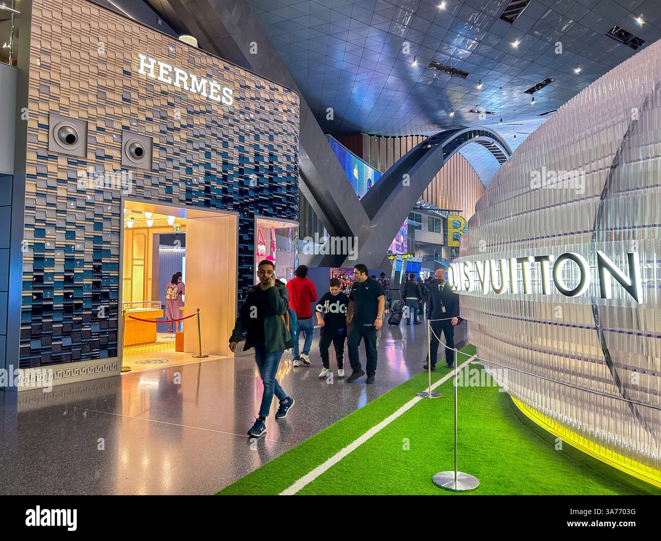 Doha, Katar, Weitwinkelblick, Im Internationalen Flughafengebäude, Menschenmassen, Walking Hall, Luxusbekleidungsgeschäfte, Hermes, Louis Vuitton Stockfoto