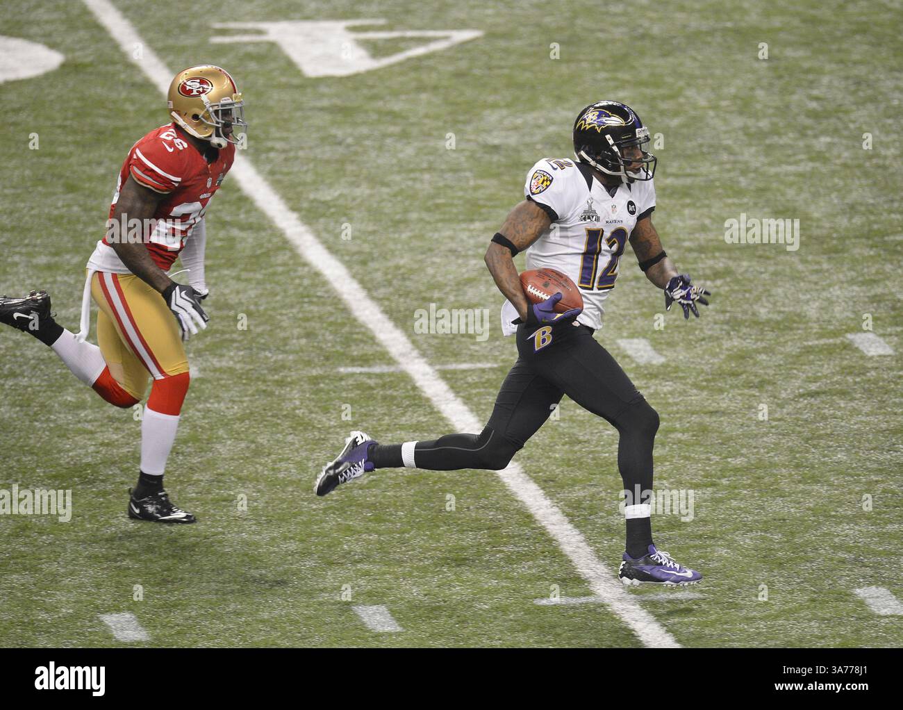 3. Februar 2013 – New Orleans, LA, USA – Jacoby Jones (12) von den Baltimore Ravens distanziert sich von Tramaine Brock (26) von den San Francisco 49ers auf seinem Weg zum Auftakt für einen Touchdown im Super Bowl XLVII im Mercedes-Benz Superdome in New Orleans, Louisiana, Sonntag, 3. Februar 2013. (Bild: © Harry E. Walker/MCT/ZUMAPRESS.com) Stockfoto