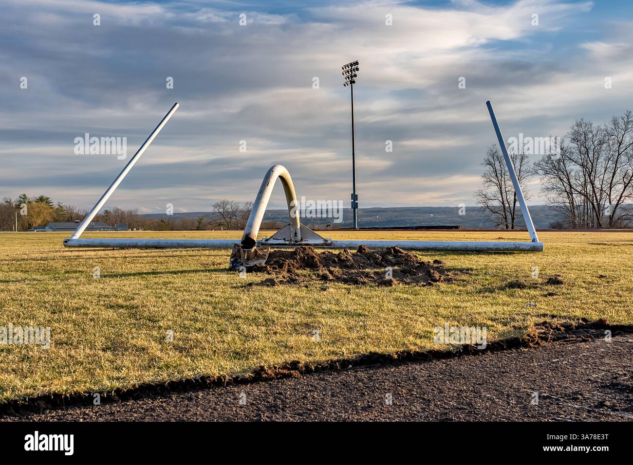Entfernung, beschädigt, eines weißen american Football Torpfosten auf einem natürlichen Rasenfeld. Stockfoto