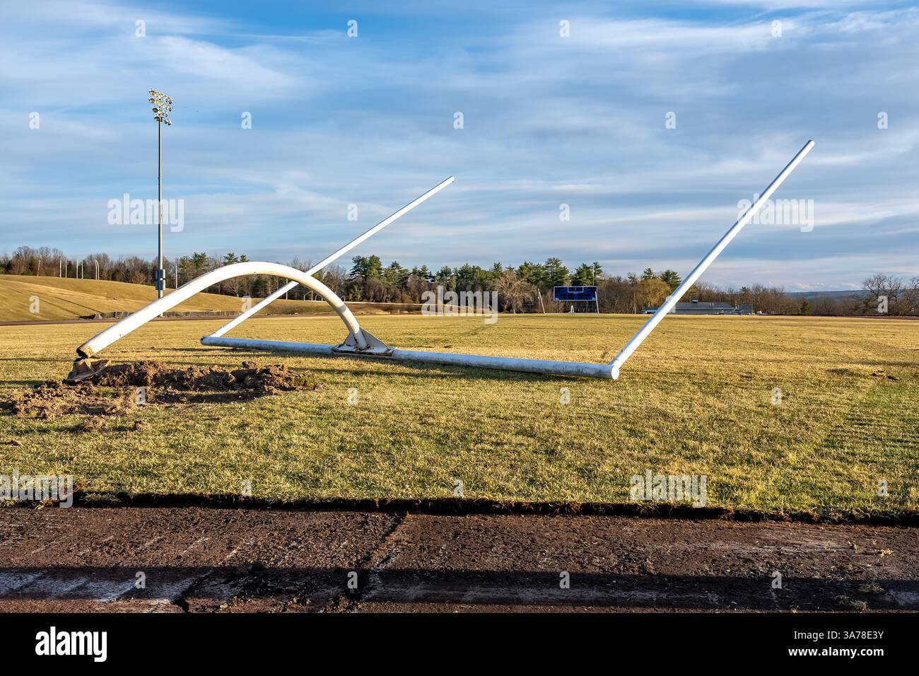 Entfernung, beschädigt, eines weißen american Football Torpfosten auf einem natürlichen Rasenfeld. Stockfoto