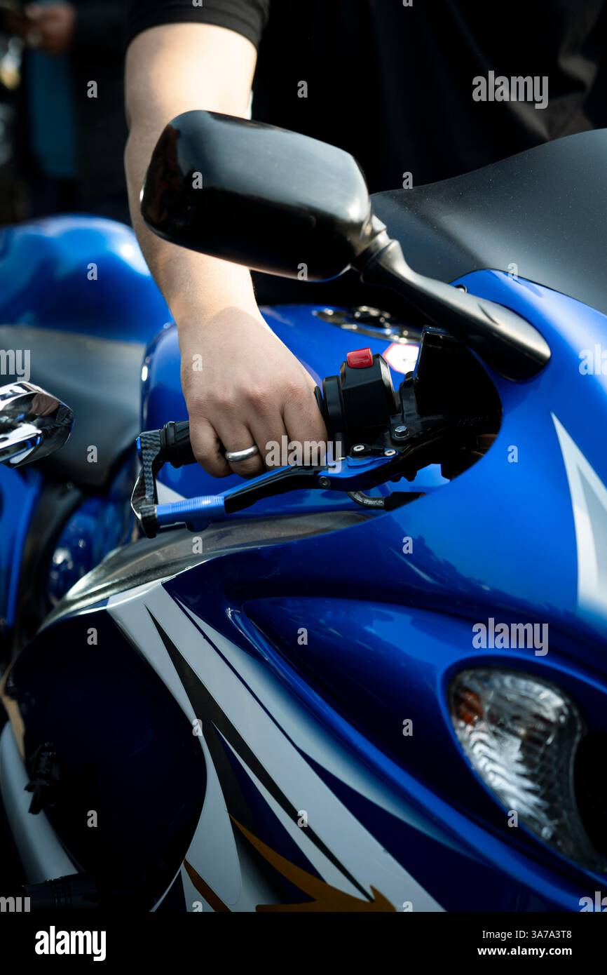Ein Fahrer, der ein blaues schweres Motorrad beschleunigt und Leistung und Bewegung zeigt. Ideal für Radfahrer und Motorradliebhaber. Stockfoto