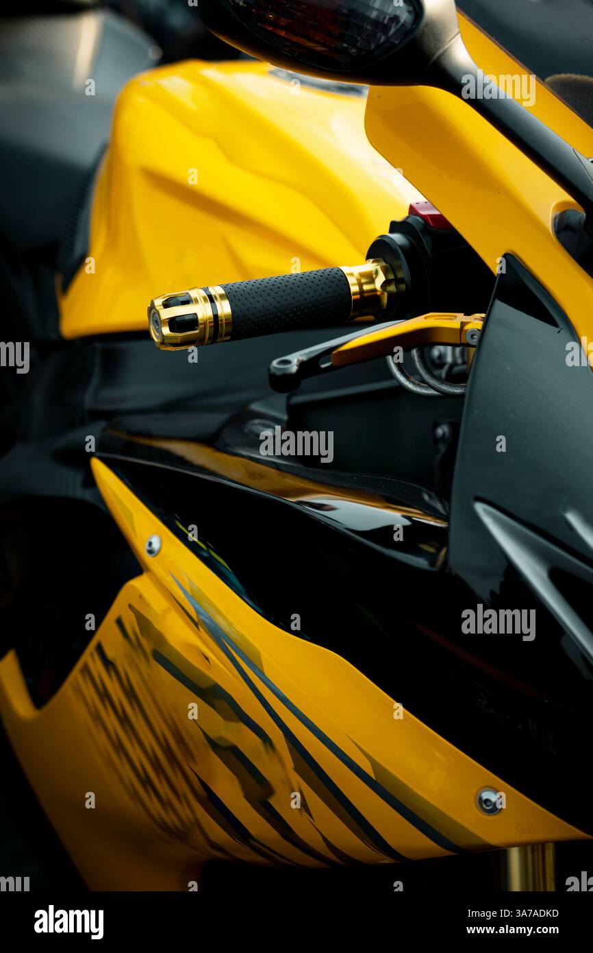 Eine enge Aufnahme eines schweren Motorrads in Gelb und Schwarz, mit auffälligem Farbkontrast und aggressiven Designelementen wie Auspuff, Felgen und Rahmen Stockfoto