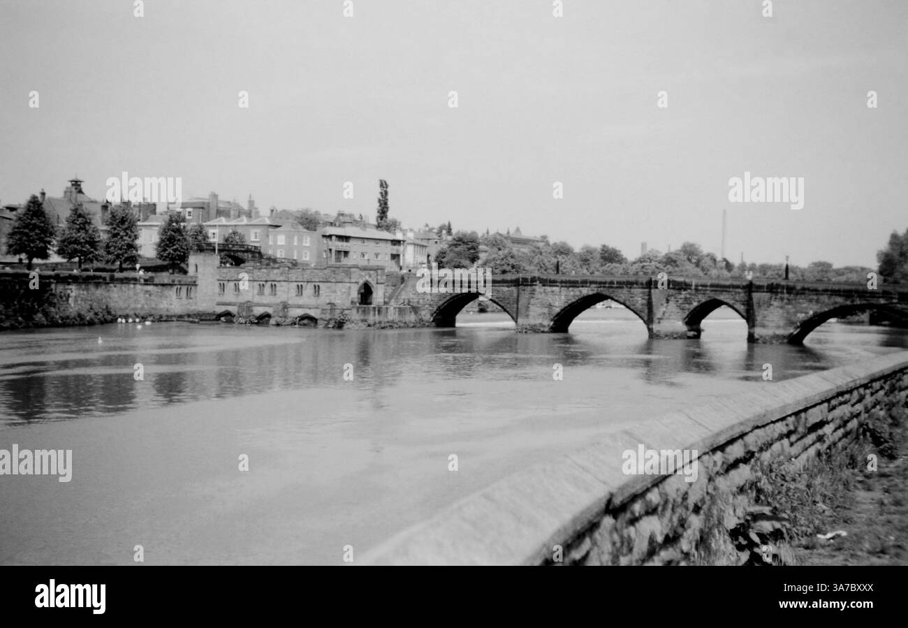 Ein Schwarzweiß-Foto aus den 1960er Jahren, das eine historische Steinbrücke über den Dee in Chester, Großbritannien, zeigt. Stockfoto