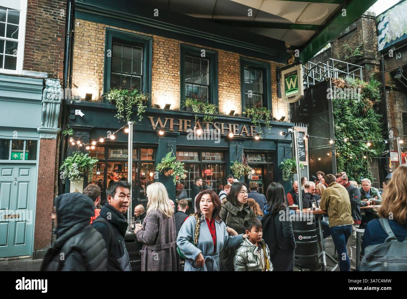 Menschen, die sich außerhalb des Wheatsheaf Pubs auf dem historischen Borough Market in Shoreditch in London in Großbritannien in Europa treffen. Stockfoto