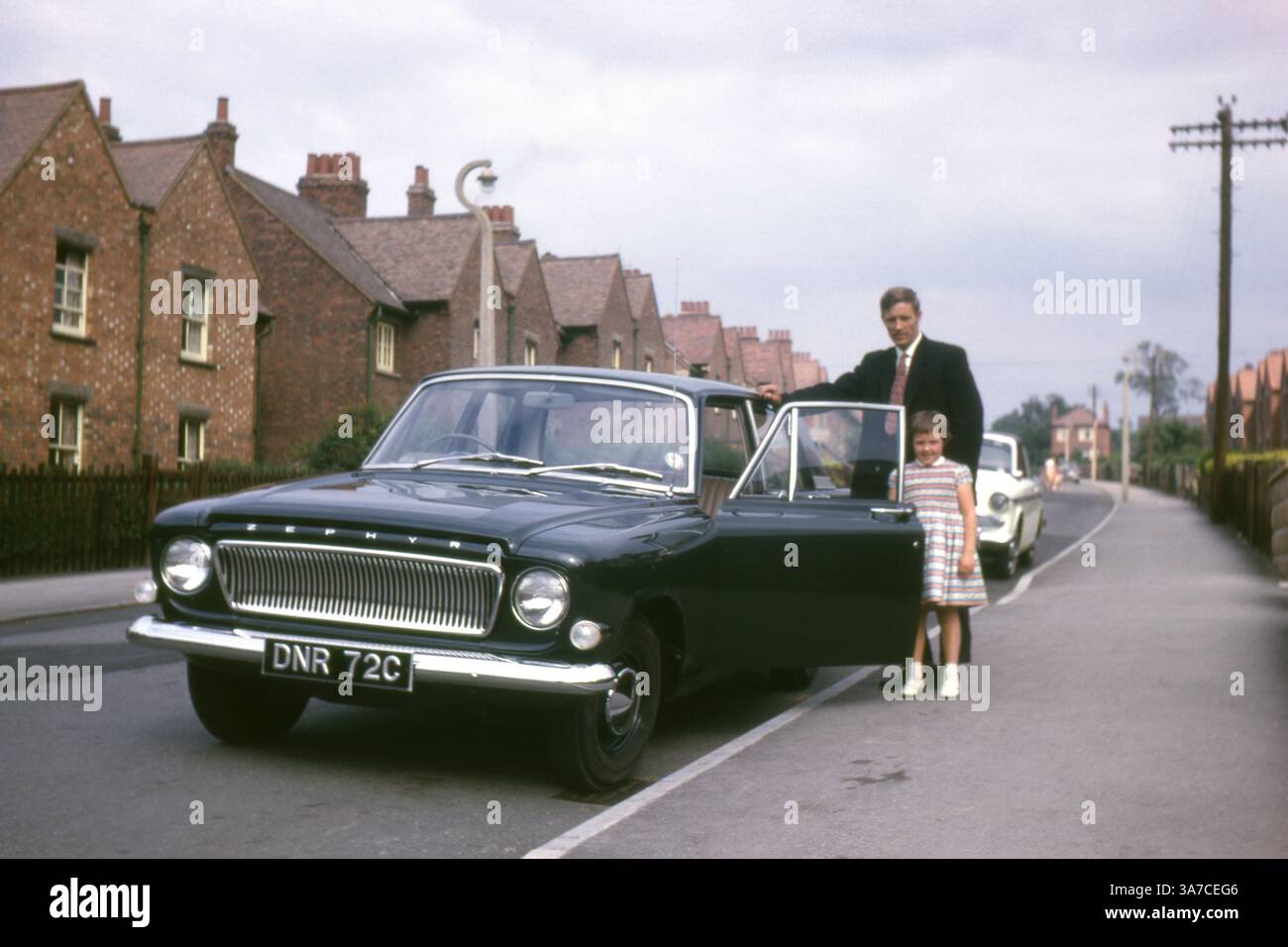 Ein stolzer Vater und seine Tochter stehen im Juli 1965 neben einem brandneuen Ford Zephyr Mk3 (C-Zulassung) in einer ruhigen britischen Vorstadtstraße. Stockfoto