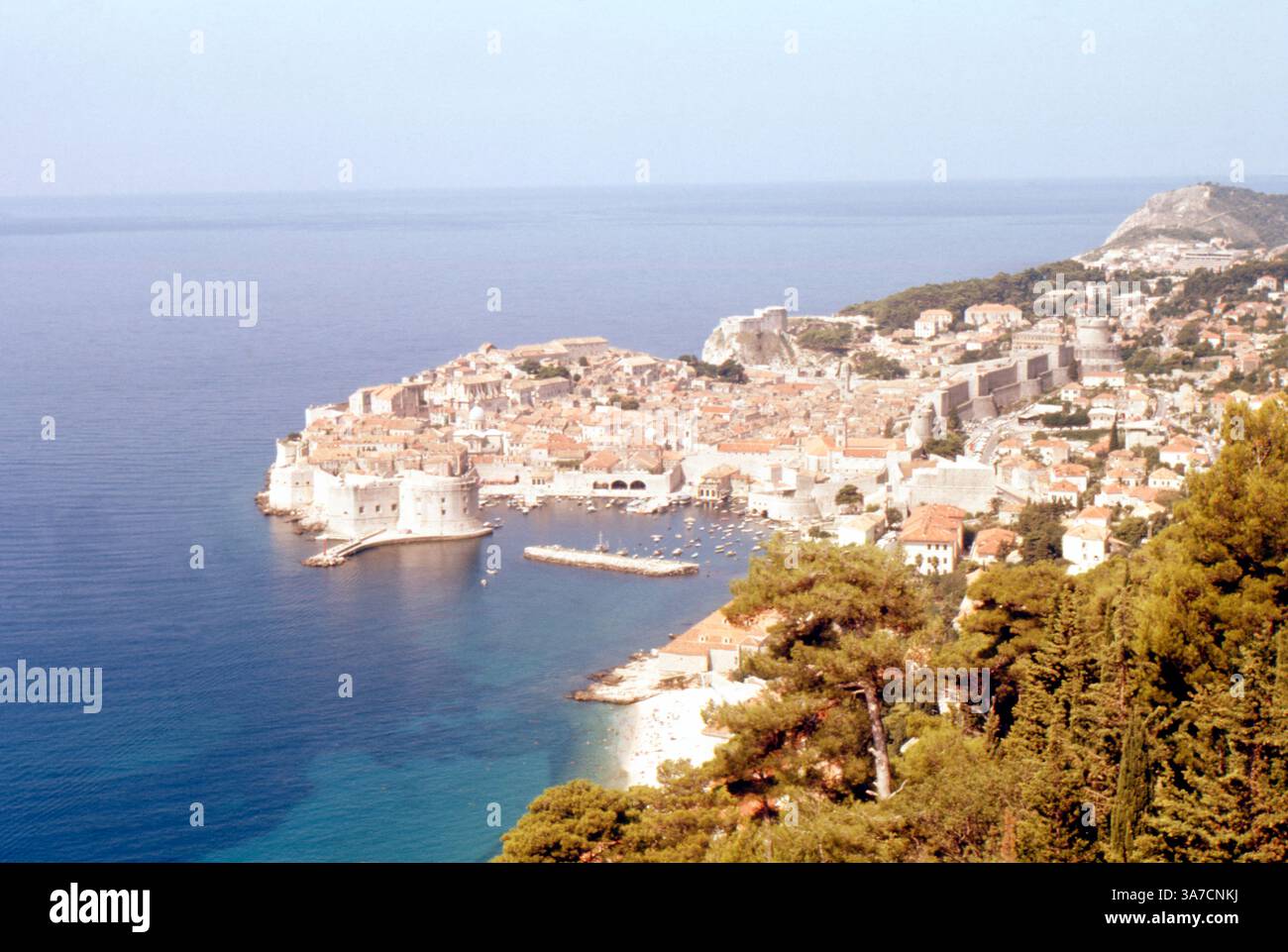 Ein Blick über Dubrovnik, Kroatien (ehemals Jugoslawien), der in den frühen 1970er Jahren vom Mount SRD aus aufgenommen wurde. Das Bild zeigt die ummauerte Altstadt mit ihren ikonischen Gebäuden mit roten Dächern entlang der Adria. Stockfoto