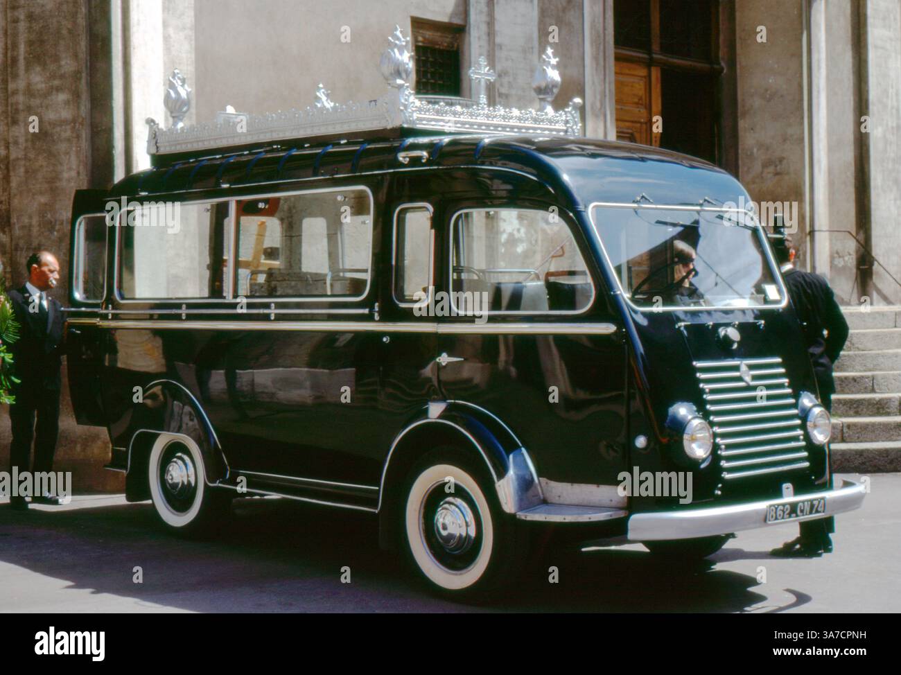 Im Juli 1972 parkte vor einem Gebäude in Thonon-les-Bains in Frankreich ein Vintage-Leichenwagen von Renault Galion. Das Fahrzeug ist elegant mit silbernen Verzierungen auf dem Dach verziert und spiegelt den zeremoniellen Stil des französischen Bestattungsverkehrs Mitte des 20. Jahrhunderts wider. Stockfoto