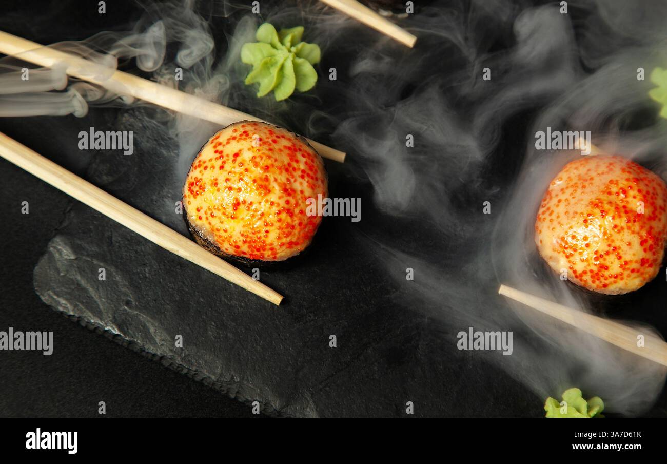 Heißes, gebackenes Sushi auf einem Teller. Dampf geht. Draufsicht Stockfoto