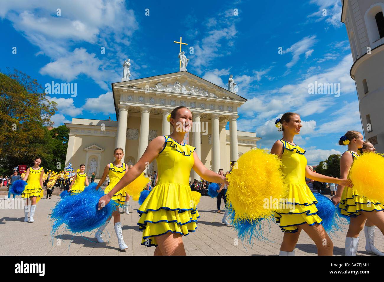 Jugendparade, Blick auf junge Frauen in gelben Kostümen, die beim litauischen Gesangs- und Tanzfestival auf dem Domplatz in Vilnius, Litauen, Parade machen Stockfoto
