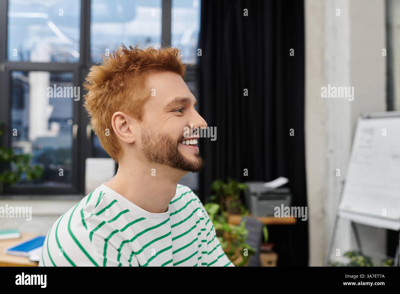 Ein fröhlicher Mann in einem gestreiften Hemd genießt das ein- und Auspacken, während er sich auf eine Bewegung vorbereitet. Stockfoto