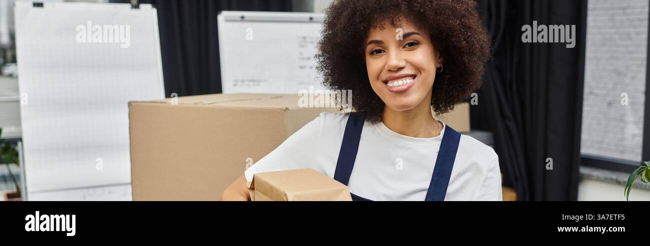 Die fröhliche Frau packt geschickt Boxen für eine Bewegung in einem schicken, modernen Ambiente. Stockfoto